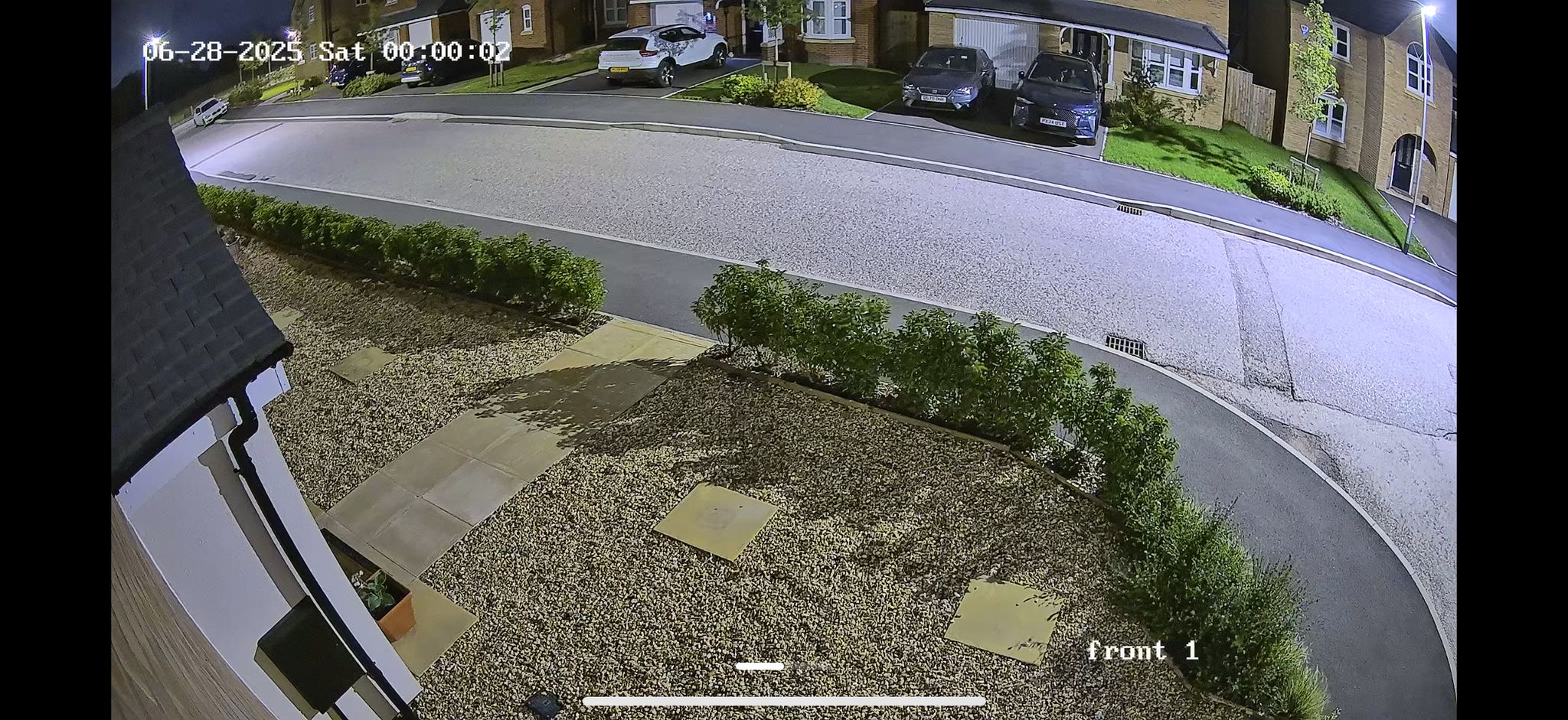 Nighttime CCTV footage showing same garden view with night vision